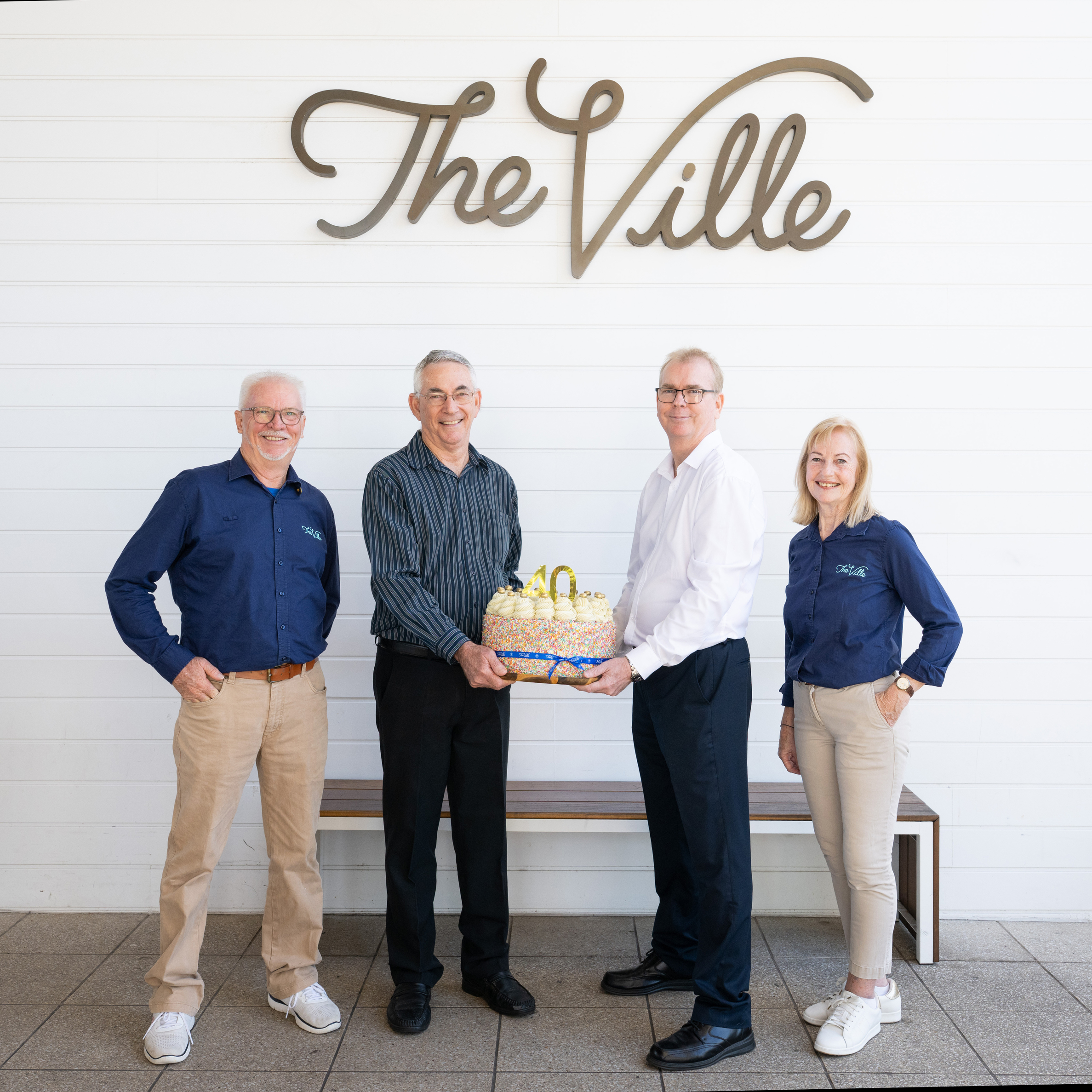 The Ville 40-year staff pictured holding a birthday cake to celebrate their milestone.