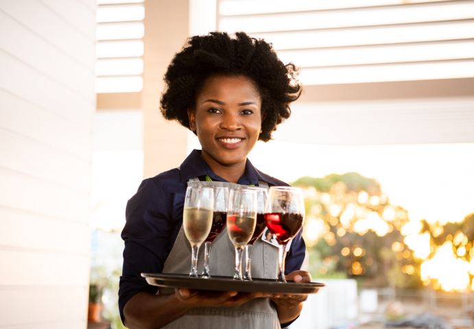 A woman serving beverages on a tray